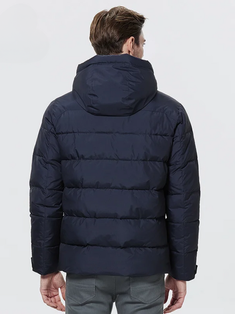 A dashing man wearing a dark blue puffer jacket with a hood facing away from the camera.