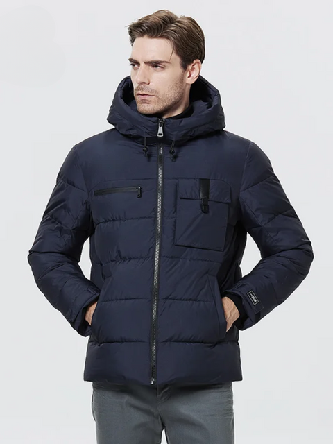 A dashing man wearing a dark blue puffer jacket with a drawstring detail on the hood, a zipper pocket on the right breast side, an exposed pocket on the left breast side, a zipper closure, velcro cuffs, and pockets on each side.