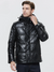 A good looking man wearing a leather jacket with thick padding, a hood, and a zipper closure.