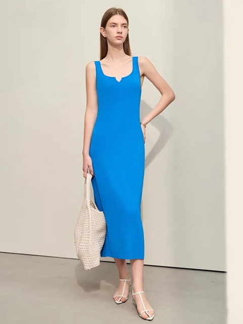 A woman wearing a simple, minimalist, sleeveless midi dresses with a v-cut out in the neckline in blue. 
