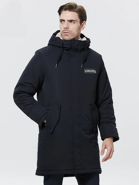 A stylish man wearing a dark blue jacket with a thick inner lining, a hood, a zipper closure, and pockets on both sides.
