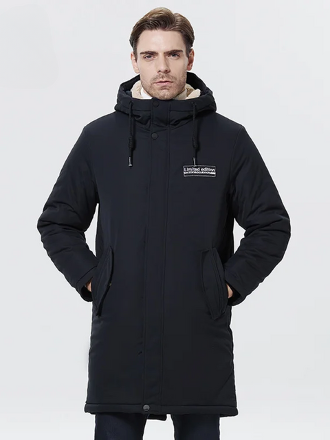 A stylish man wearing a dark blue jacket with a thick inner lining, a hood, a zipper closure, and pockets on both sides.