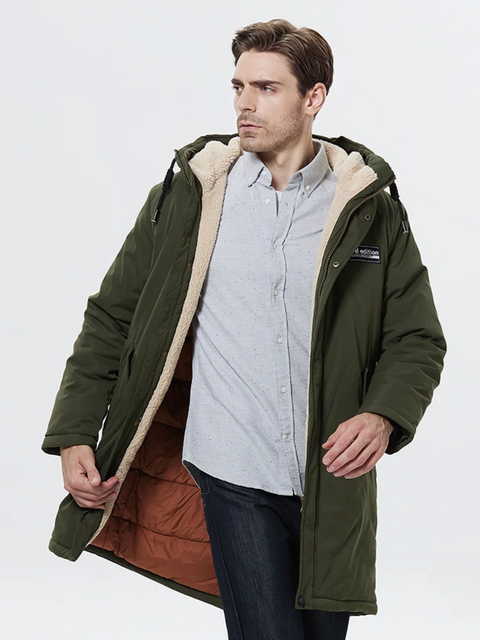 A stylish man wearing a army green jacket with a thick inner lining, a hood, and a zipper closure over a button up shirt and classic jeans.