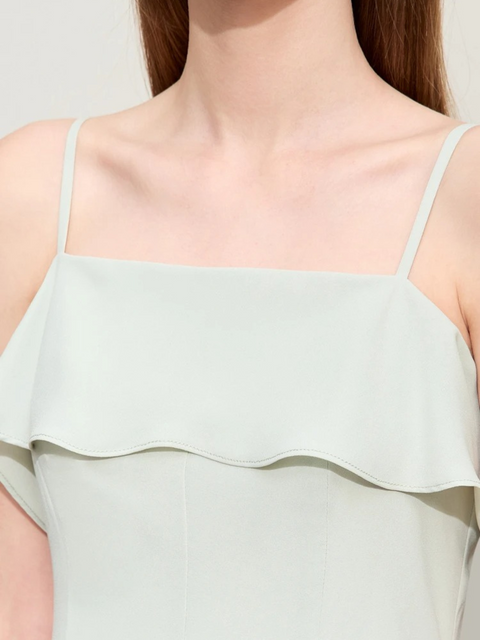 Close up of a mint green dress with thin straps.